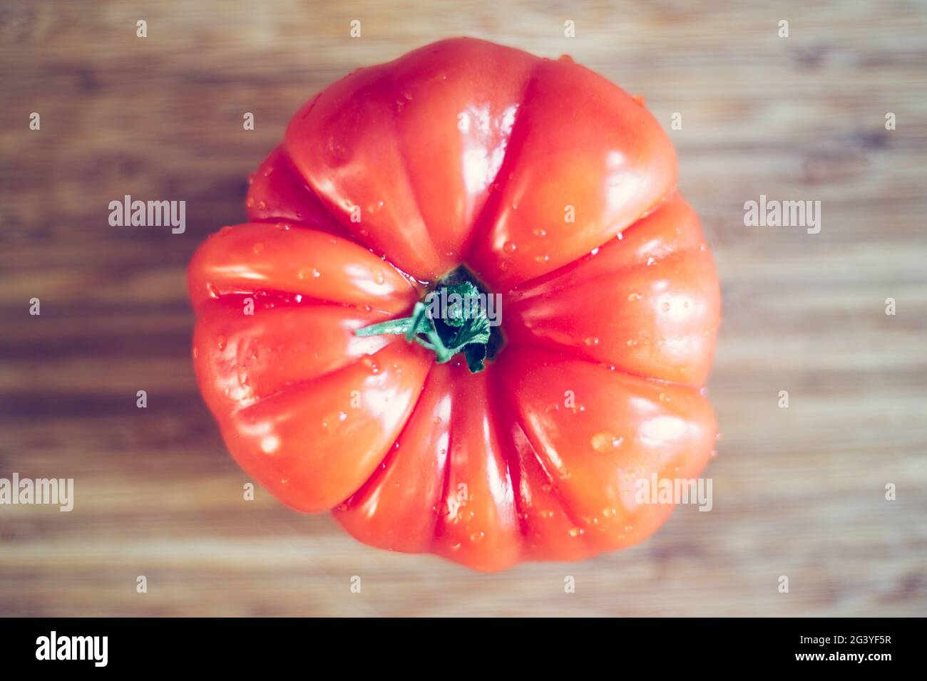 Oxheart tomatoes. Tomato on a bamboo wood plate. Stock Photo