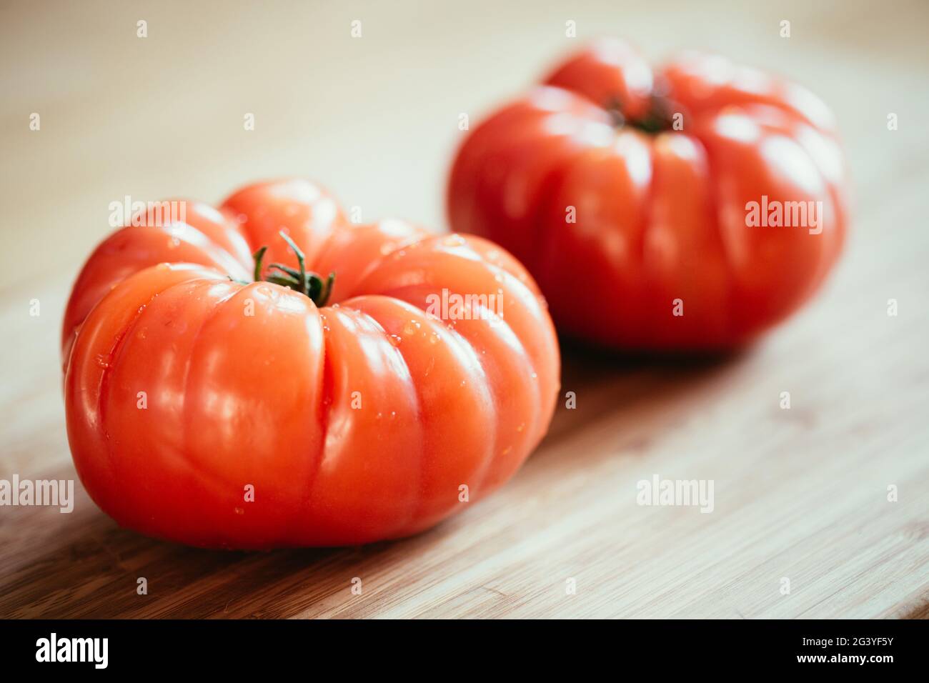 Oxheart tomatoes. Tomatoes on a bamboo wood plate. Stock Photo