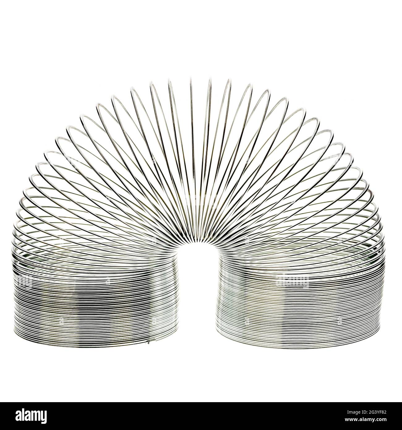 Metal Slinky spring toy on white background Stock Photo