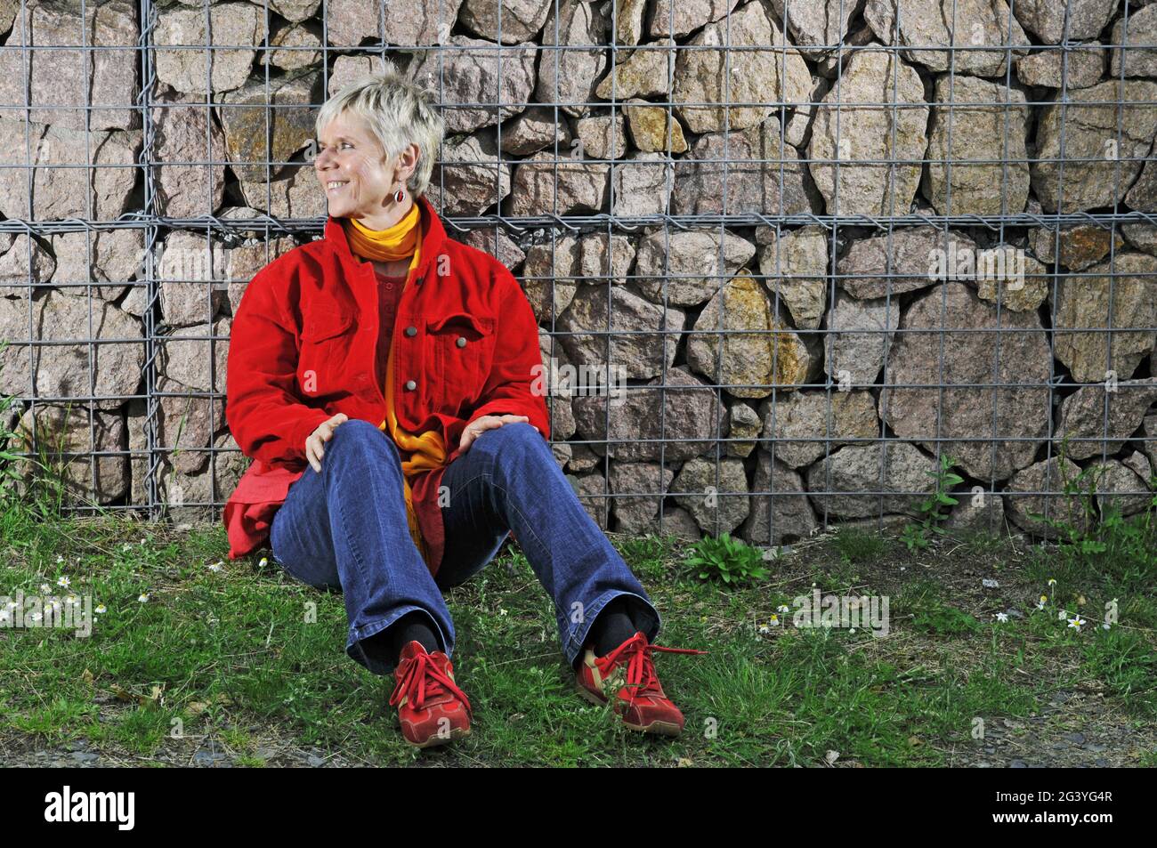Sitting by the wall look away Stock Photo