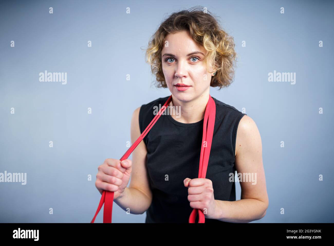 Sports woman exercising with a resistance band. Slim girl in good shape. People, sport and fitness concept. Exercise bands worki Stock Photo