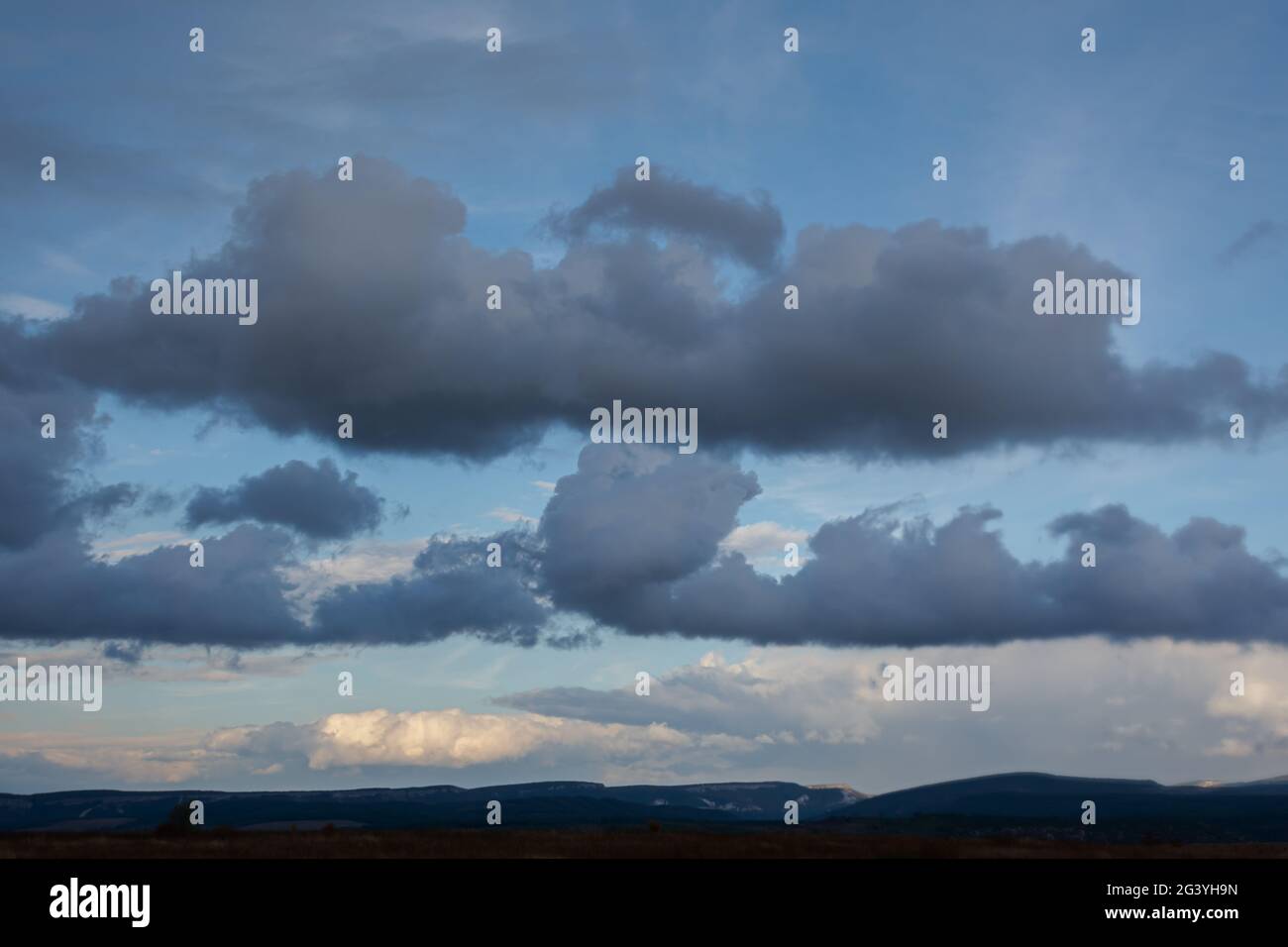 Storm clouds over the field. Gray, long, huge clouds hung in the sky. It's  going to rain soon. Rural summer landscape. The concept of worsening weathe  Stock Photo - Alamy