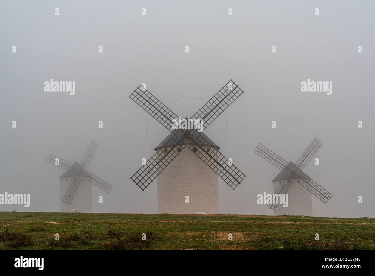 A view of the windmills of Campo de Criptana in La Mancha on a very foggy morning Stock Photo