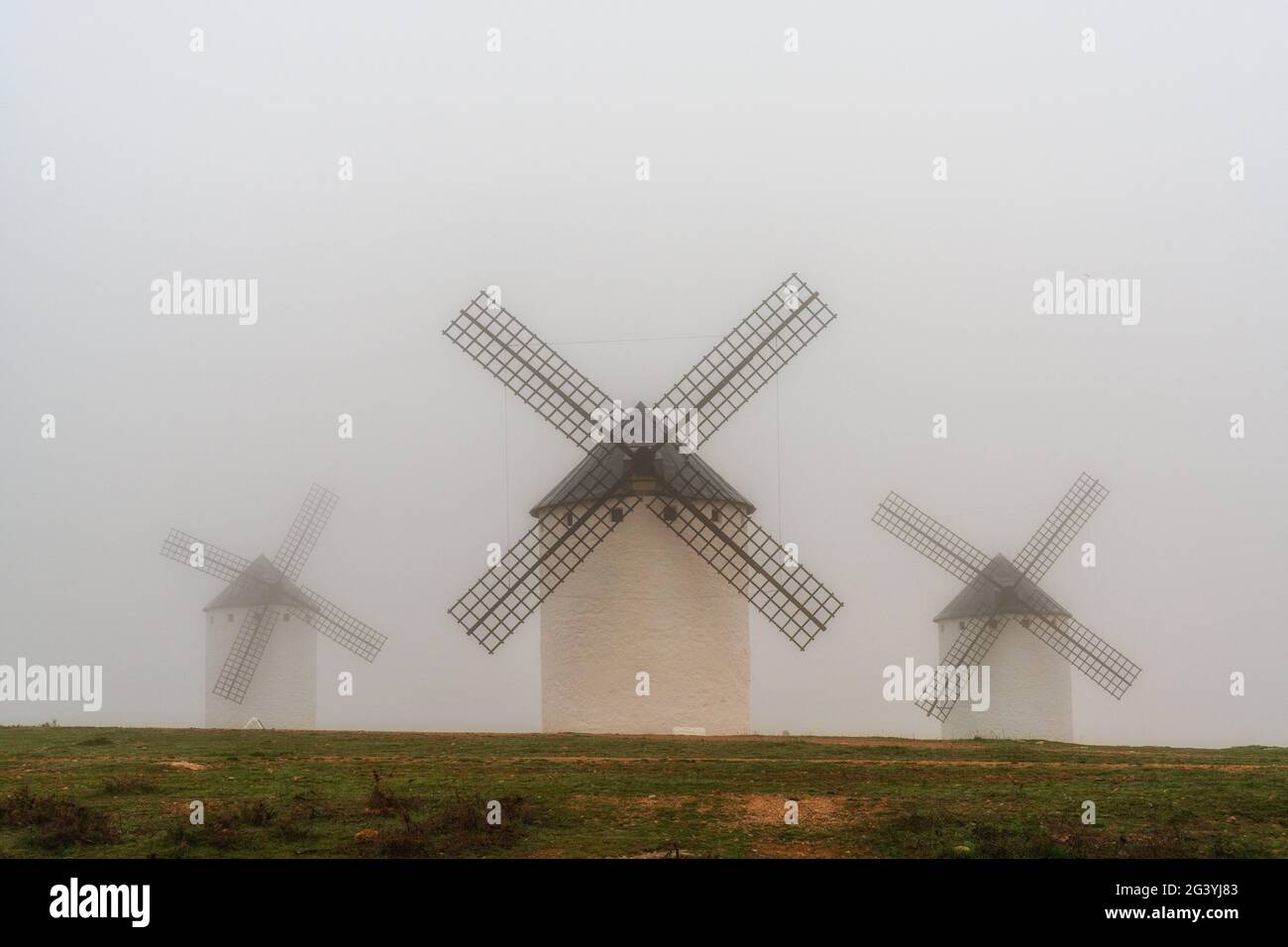 A view of the windmills of Campo de Criptana in La Mancha on a very foggy morning Stock Photo