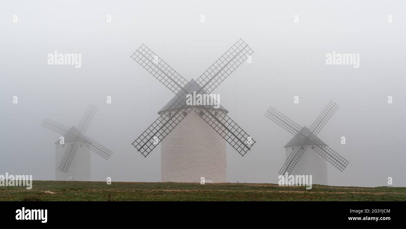 View of the windmills of Campo de Criptana in La Mancha on a very foggy morning Stock Photo
