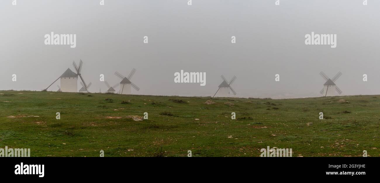 A panorama view of the windmills of Campo de Criptana in La Mancha on a very foggy morning Stock Photo