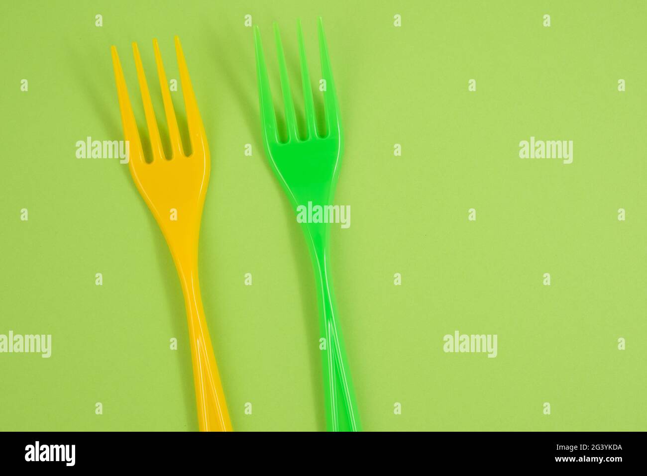 Plastic forks on a green background Stock Photo Alamy
