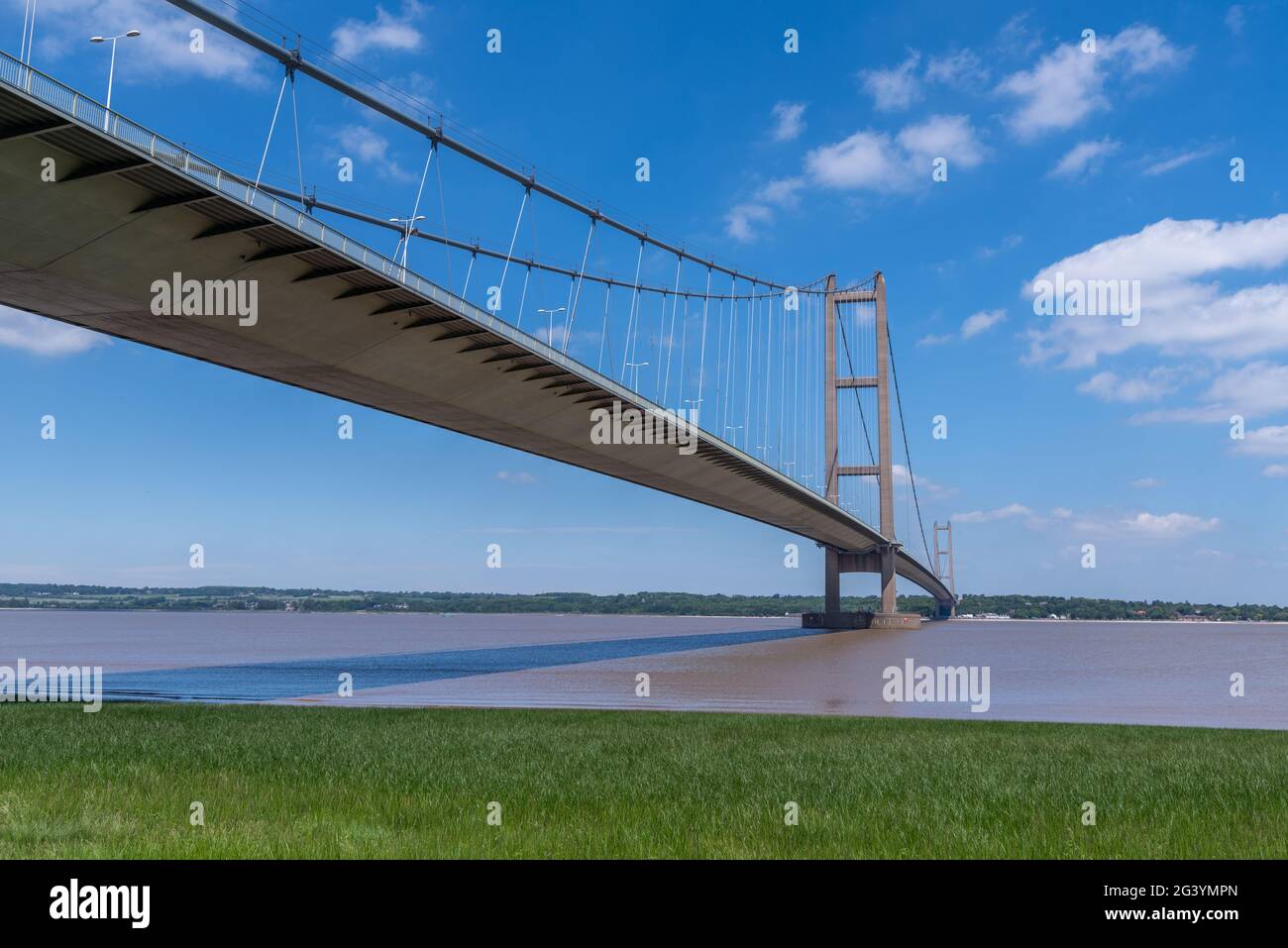 View of the Humber suspension bridge and river with blue sky on a bright sunny day. Stock Photo