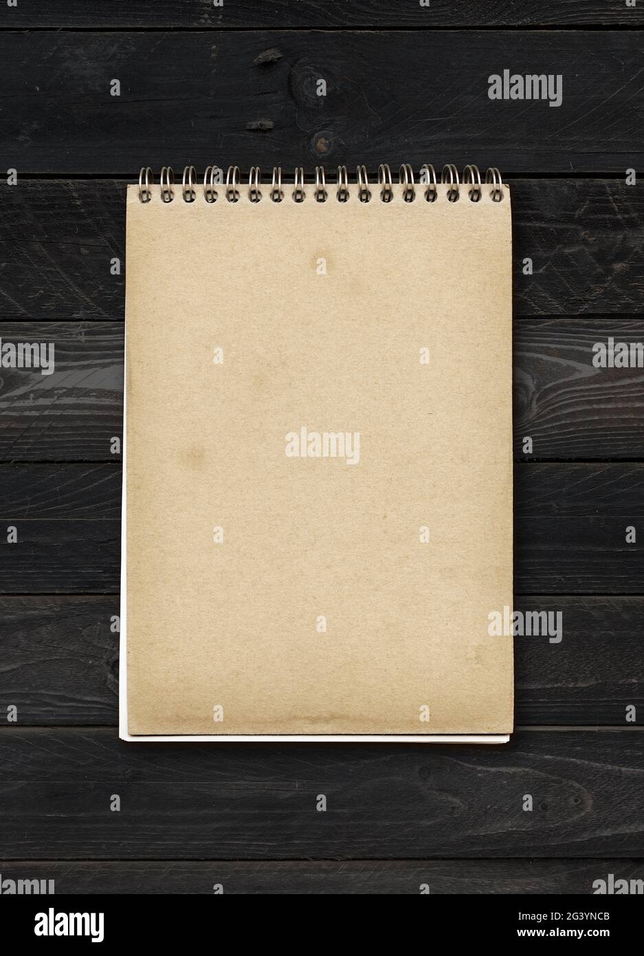 Closed spiral Note book on a black wood table Stock Photo