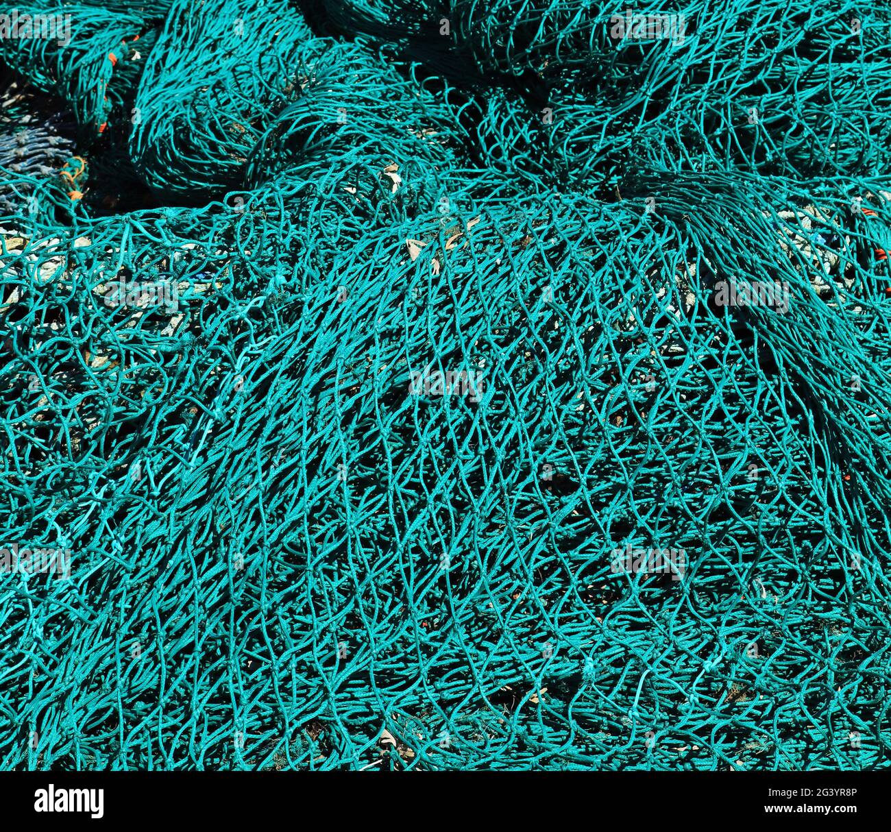 Fishing tackle, nets and ropes, stacked on the quay side at the fishing