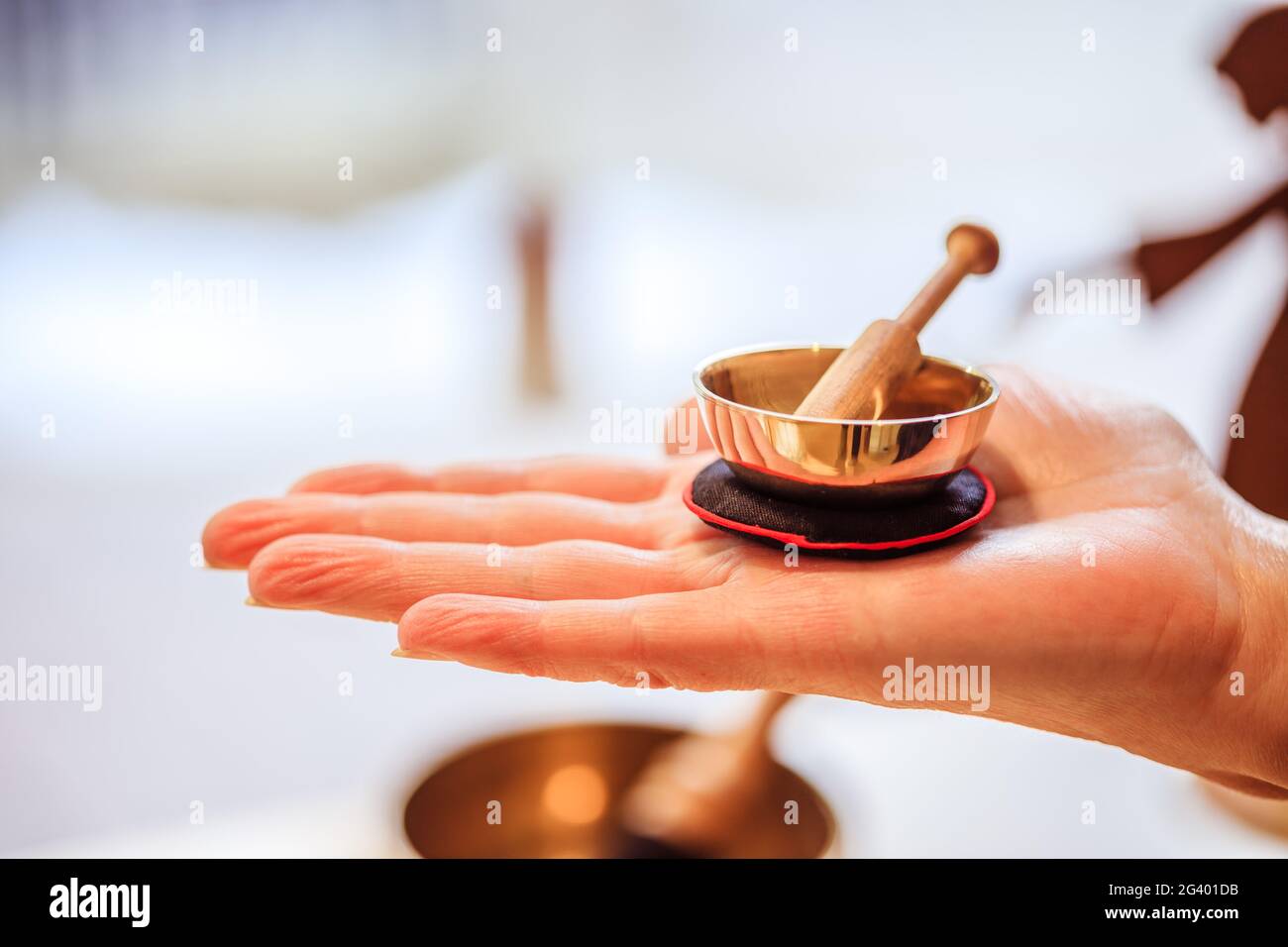 Baby singing bowl: Small metal singing bowl in the hand of a woman. Blurry  background Stock Photo - Alamy