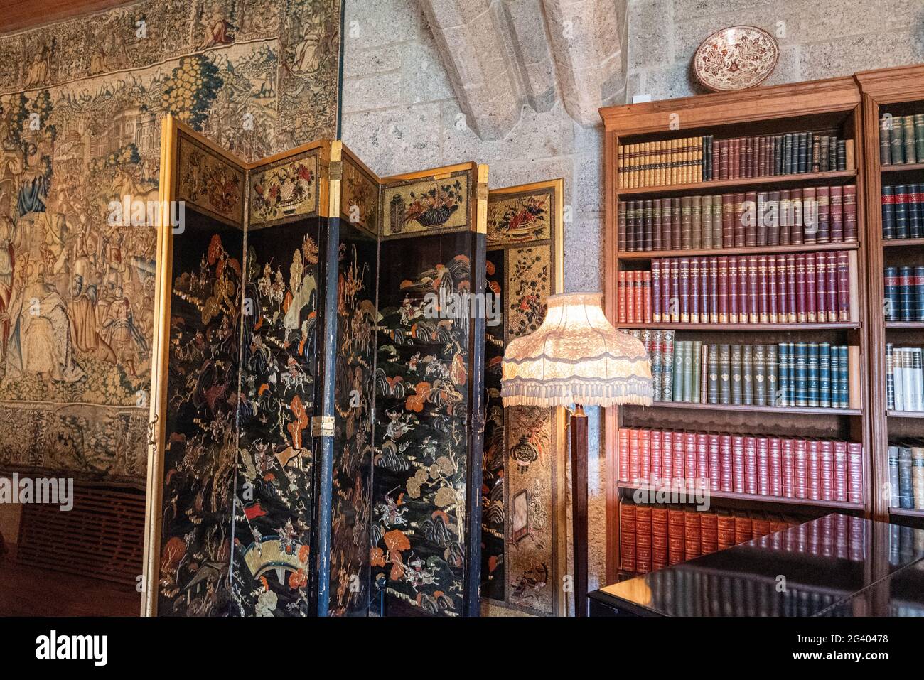 Antique folding screen, lampstand and bookcase, Castle Drogo, Dartmoor, Devon Stock Photo