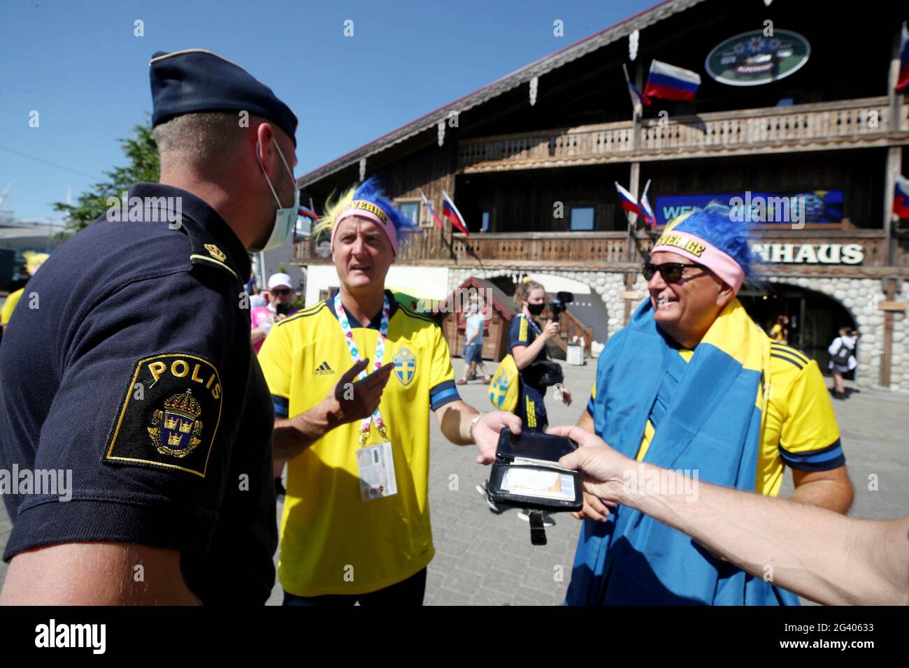St Petersburg, Russia. 18th June, 2021. Swedish police officer and  supporters of the Swedish national football team cheer ahead of a UEFA Euro  2020 group stage match between Slovakia and Sweden, outside