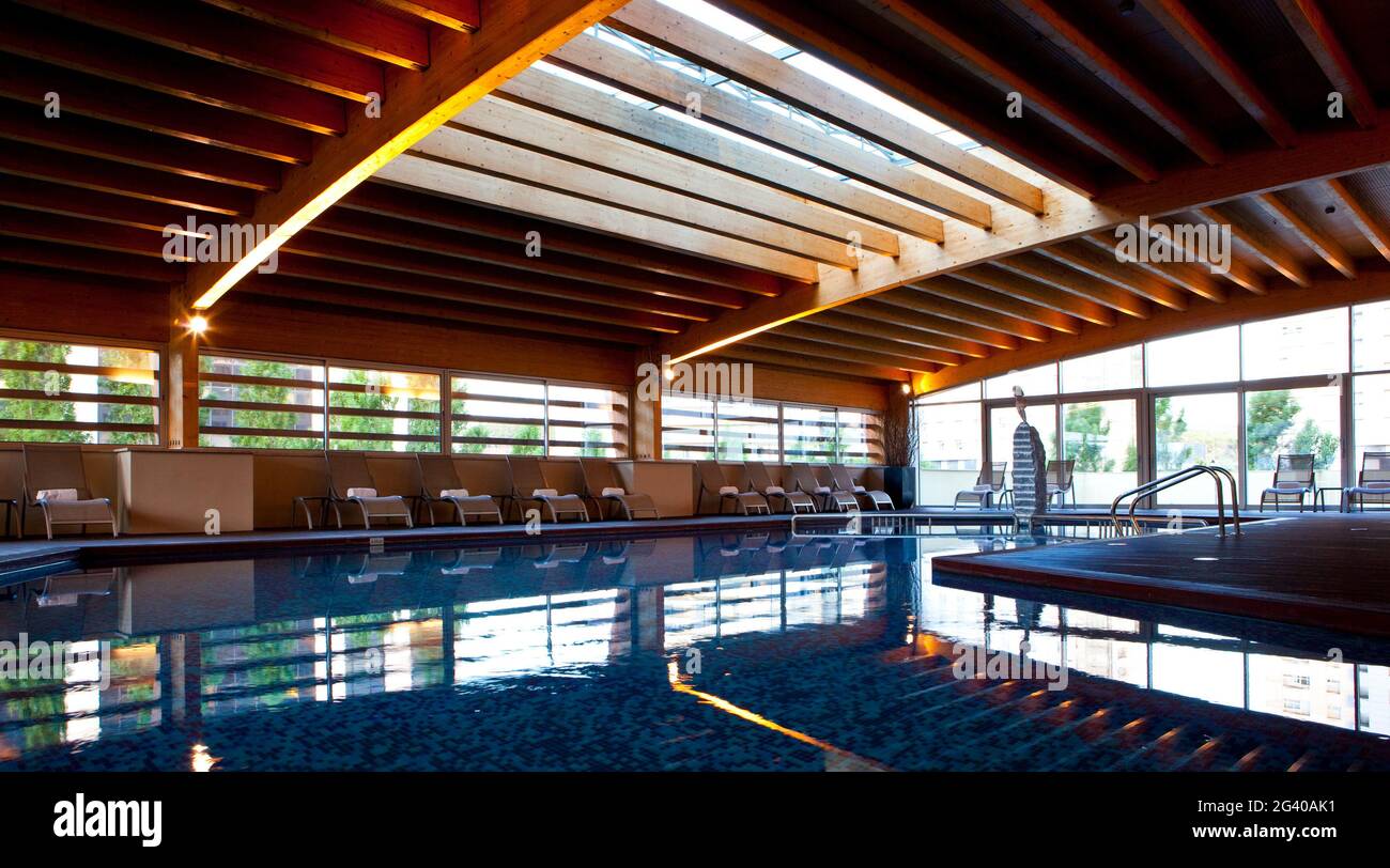 Indoor pool, with rooftop lighting and large windows illuminating the wooden structure, Madrid, Spain. Stock Photo