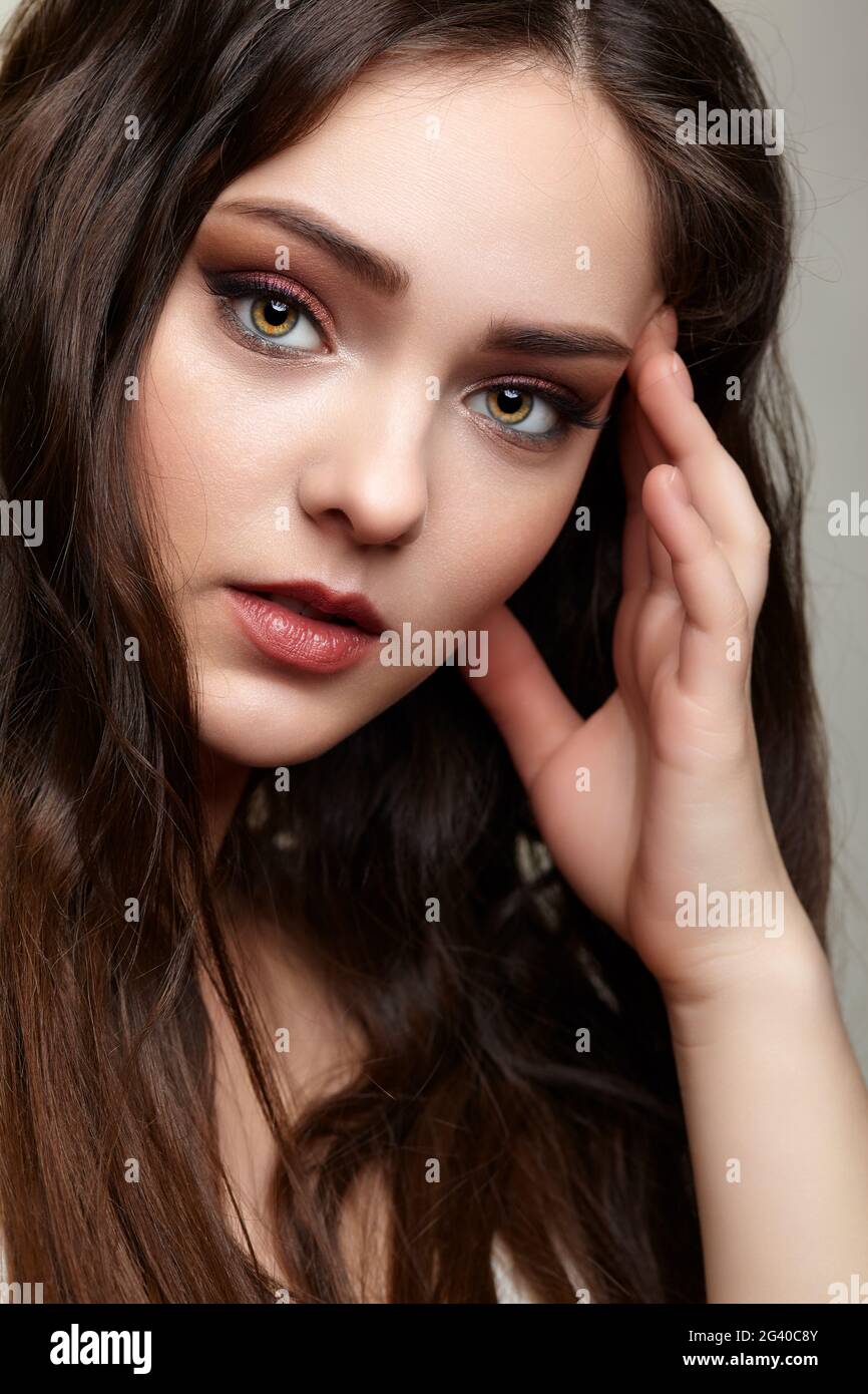 Beauty portrait of young woman. Brunette girl with evening female makeup. Stock Photo