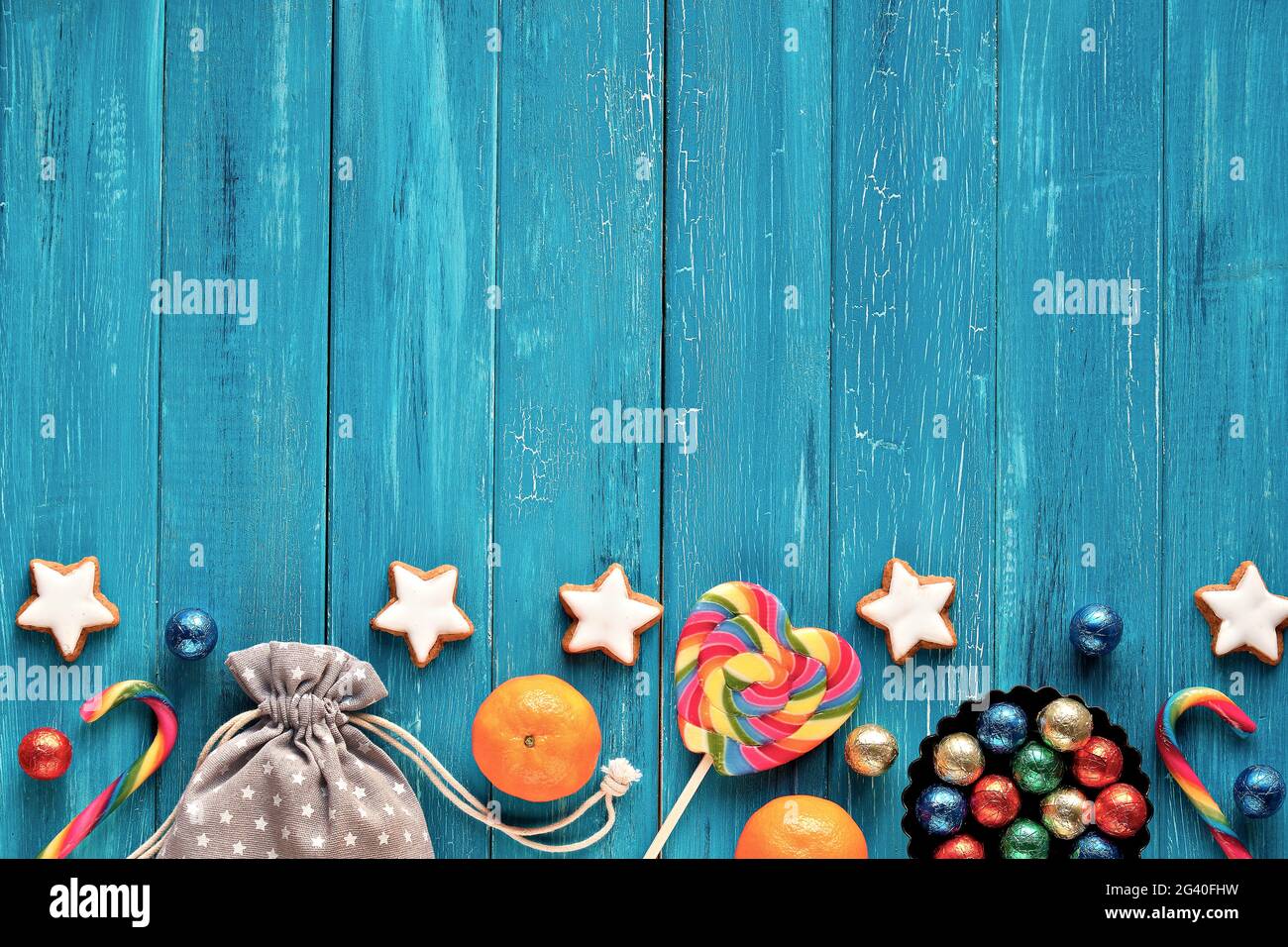 Saint Nicholas Day or Nikolaus Tag in German language. Traditional holiday in Germany, Europe. Decorative border - sweets, candy, cookies, satsuma and Stock Photo