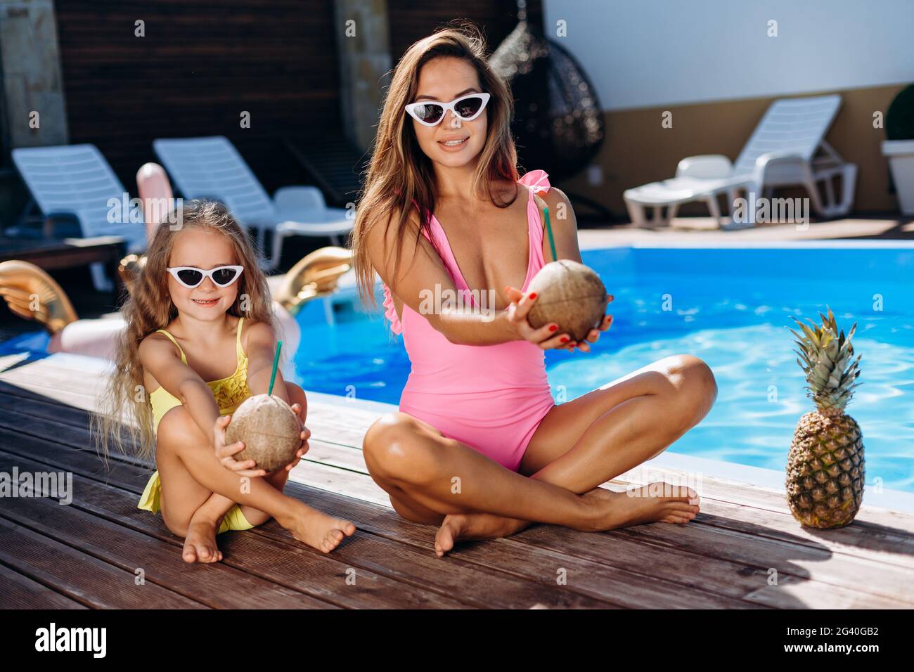 Outdoor portrait of beautiful woman mother in bikini and her cute daughter  in swimsuit. Little girl and her mom look to the camera and smile. Stretch  Stock Photo - Alamy