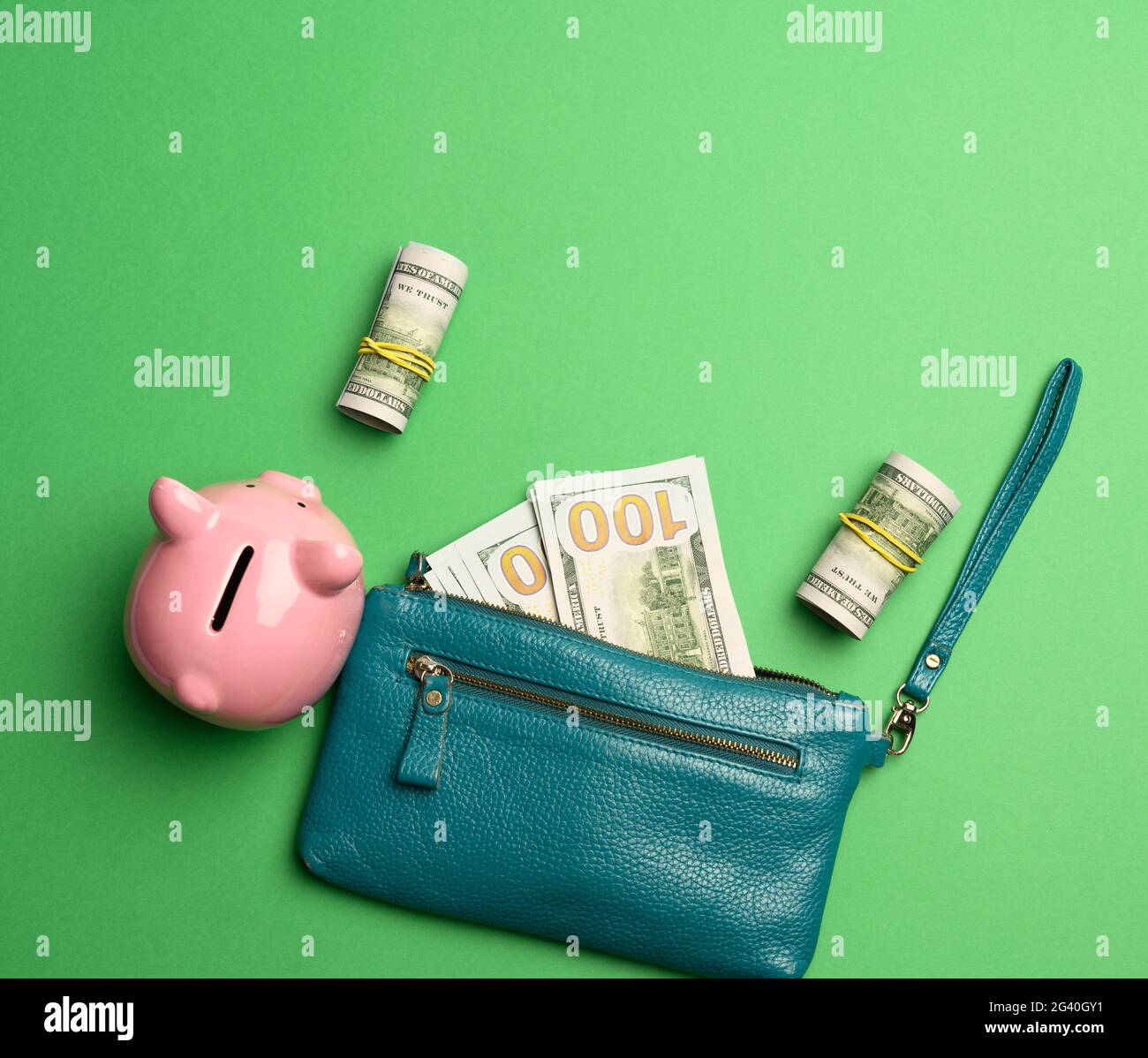 Ceramic pink piggy bank and paper american us dollars on green background Stock Photo