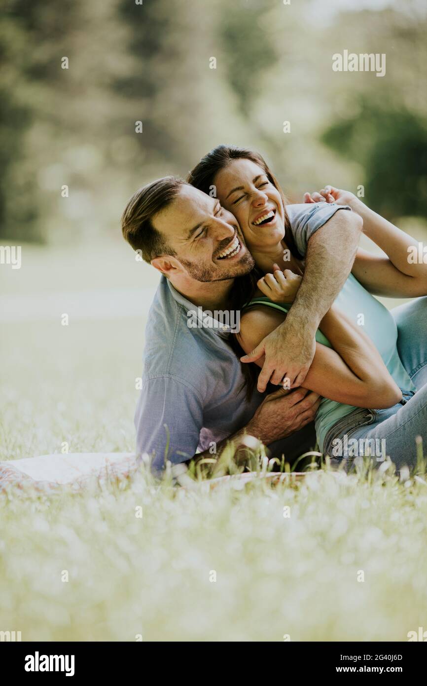 Affectionate young couple sitting on the green grass at the park Stock ...