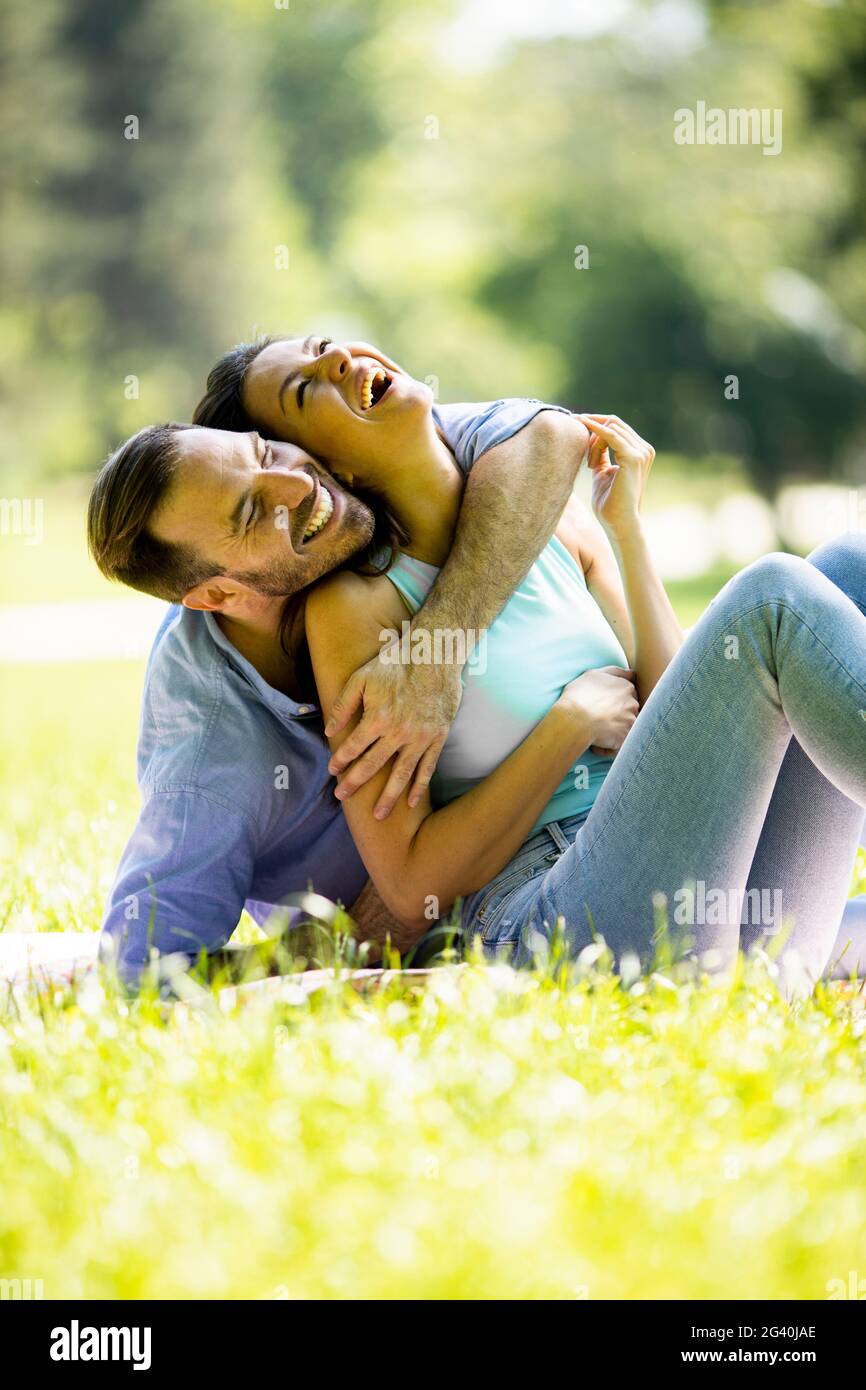 Affectionate young couple sitting on the green grass at the park Stock ...