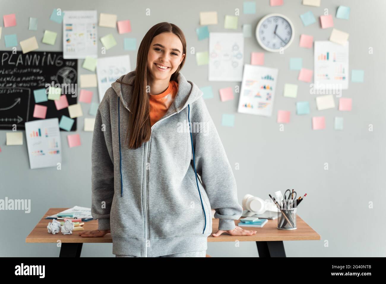Smiling girl in a gray hooded sweater 