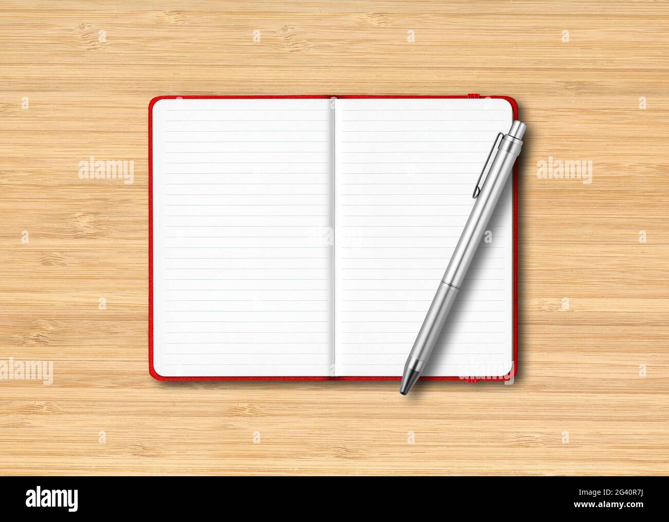 Red open lined notebook with a pen isolated on wooden background Stock Photo