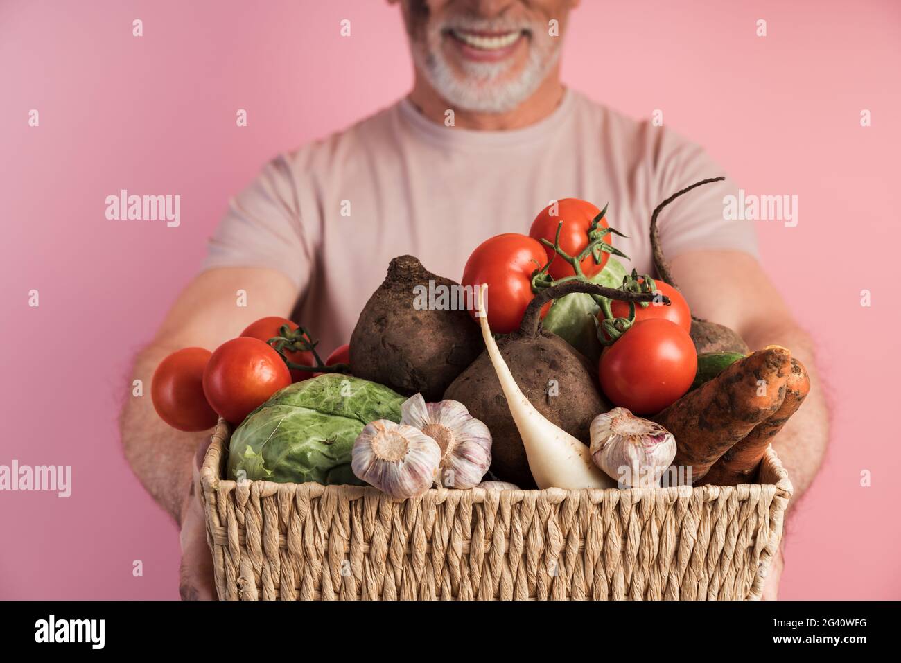 Close view, basket with vegetables, man holding fresh vegetables. Isolated on pink background, household concept., Close view, basket with vegetables, Stock Photo