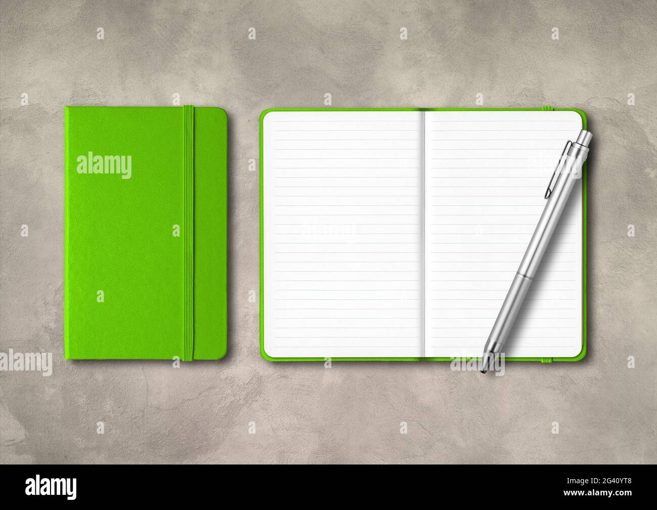 Green closed and open lined notebooks with a pen on concrete background Stock Photo