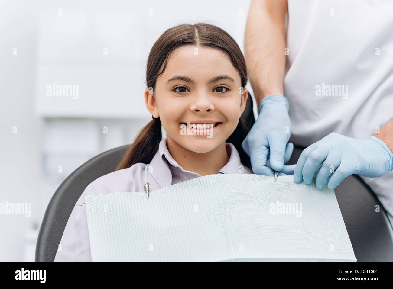 Dentist prepares a small patient for dental treatment. Attractive