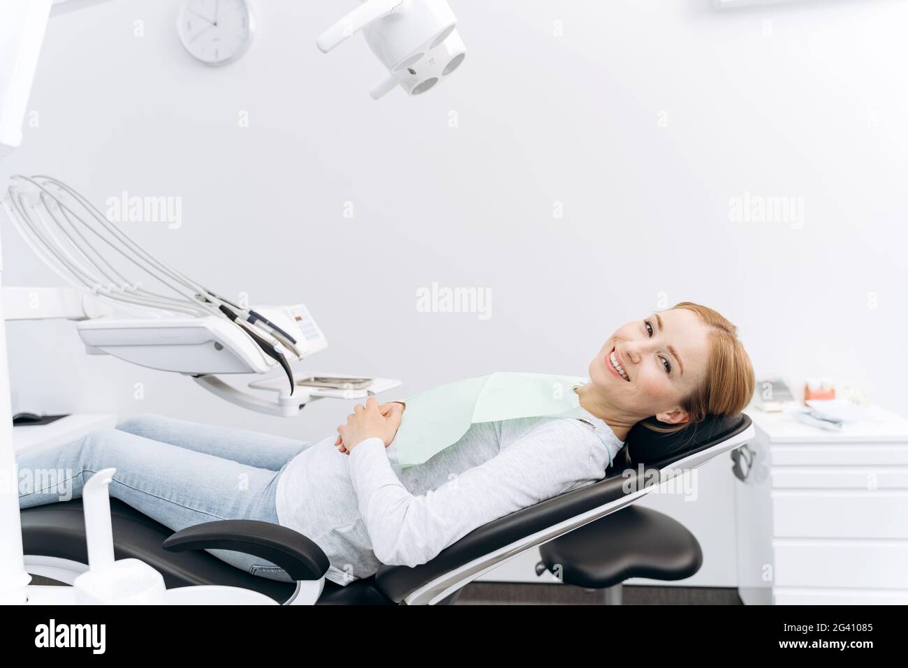 Patient is lying in a dental chair, waiting for the dentist. Attractive woman in the dental office Stock Photo