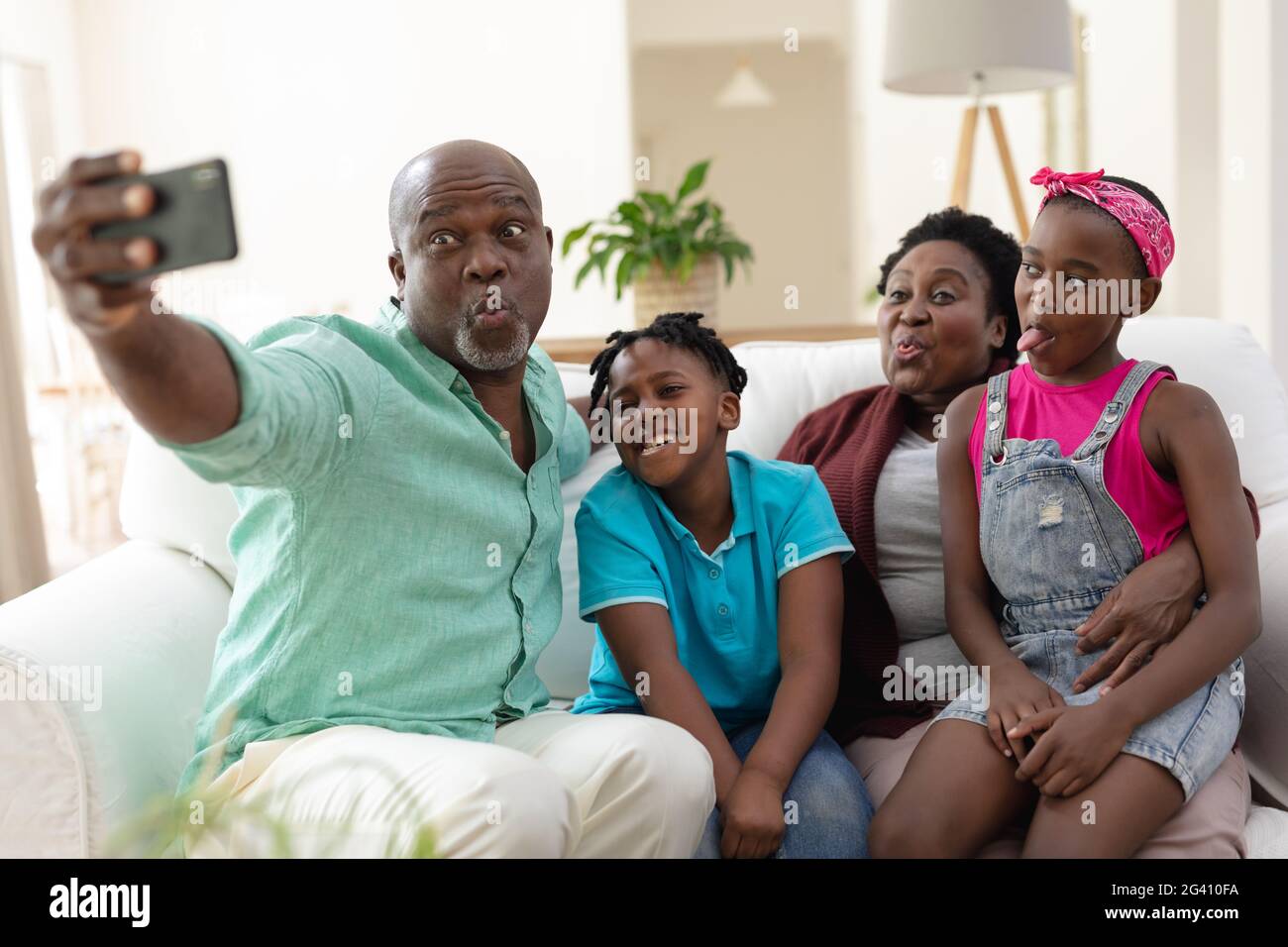 African american grandfather and grandmother on couch making faces with grandchildren taking selfie Stock Photo