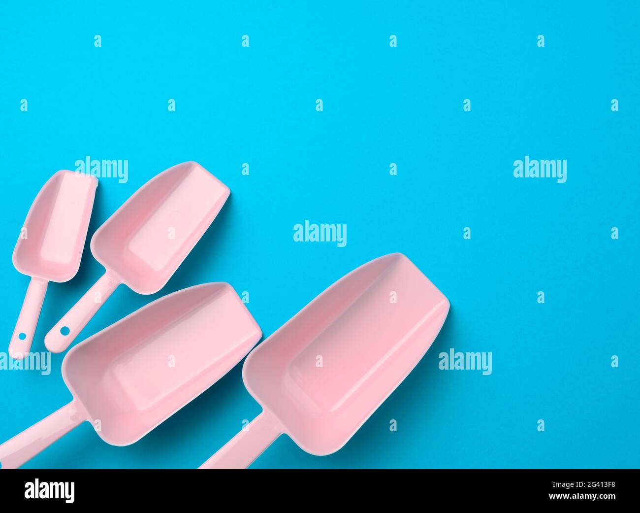 Set of plastic kitchen scoops for bulk products on a blue background