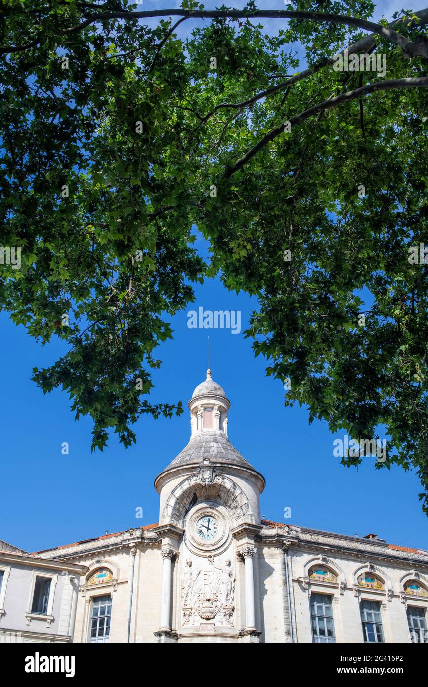 Clock on classic end of 19th century building junction of Rue Jean Reboul and Boulevard Victor Hugo from Arena Nimes France. Facade of the Lycee Alpho Stock Photo