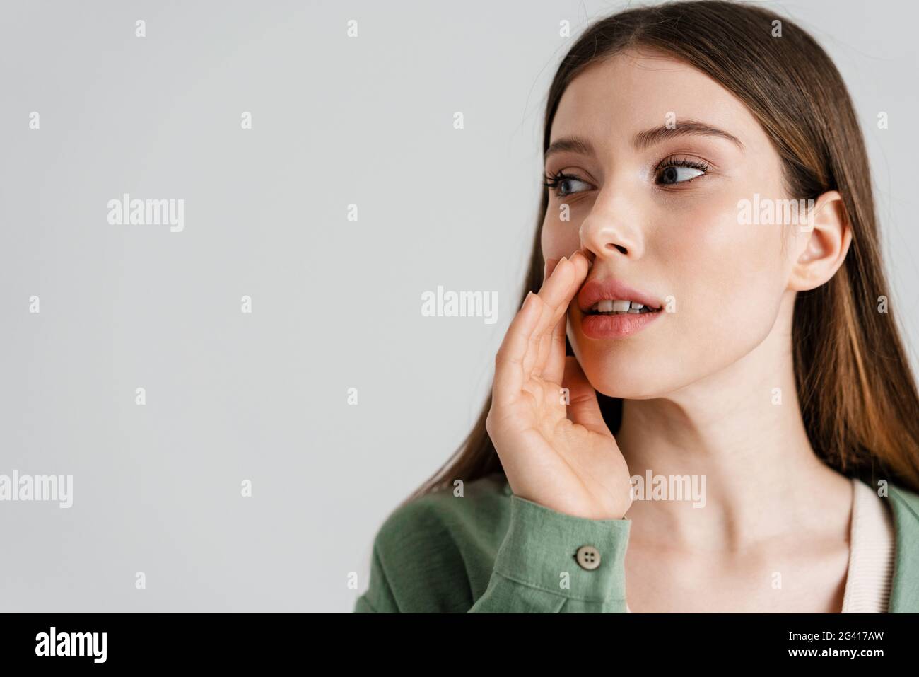 Focused caucasian girl whispering and looking aside isolated over white ...