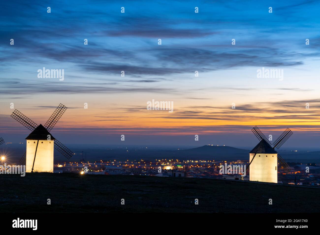 View of the historic white windmills of La Mancha above the town of Campo de Criptana at sunset Stock Photo