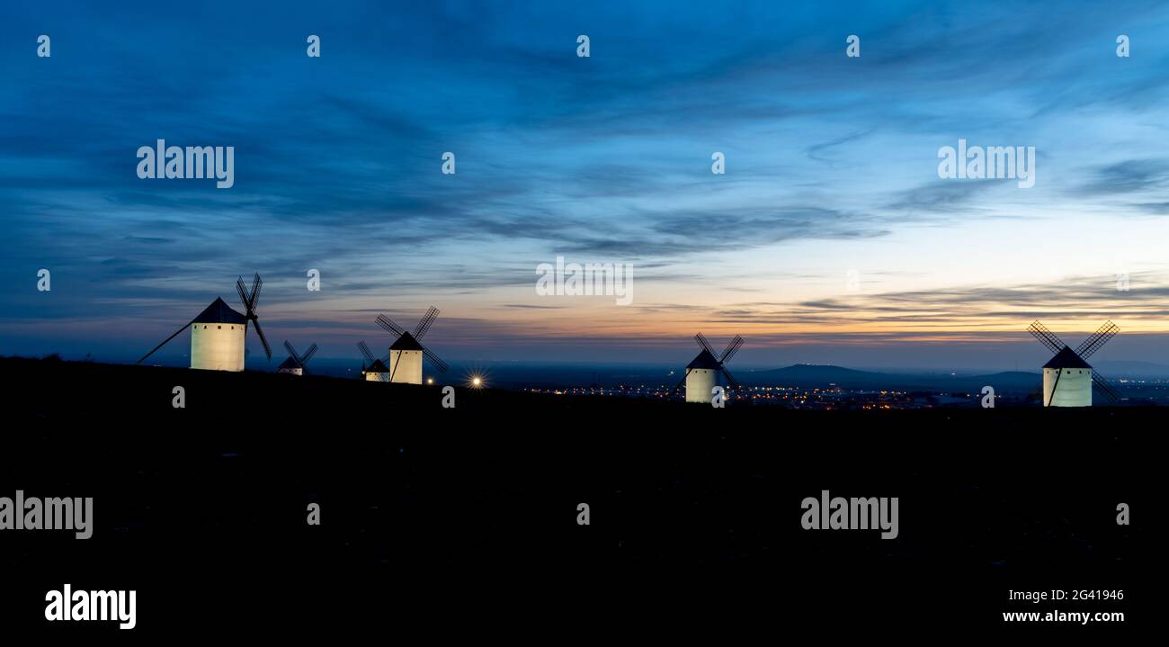 View of the historic white windmills of La Mancha above the town of Campo de Criptana at sunset Stock Photo