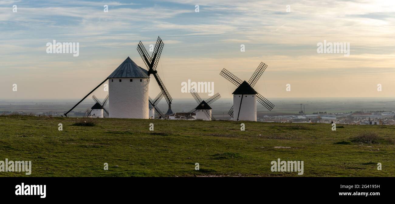 The historic whitewashed Spanish windmills of La Mancha above the town of Campo de Criptana in warm evening light Stock Photo