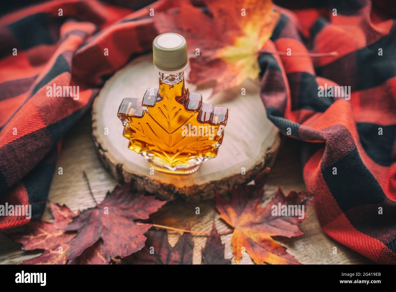 Maple syrup gift bottle in red maple tree leaves for tourist souvenir