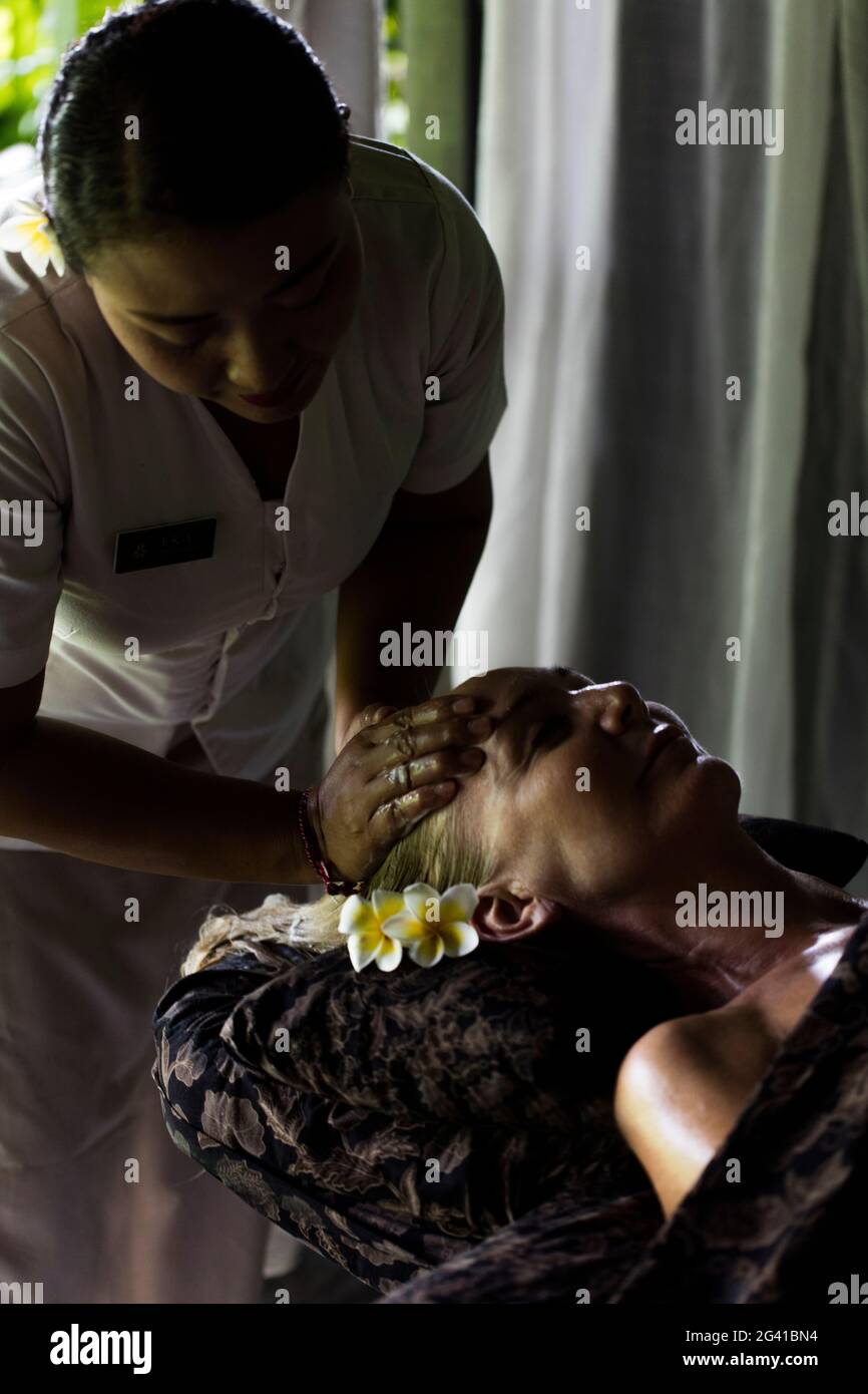Face massage performed on woman by Balinese therapist. Bali, Indonesia. Stock Photo