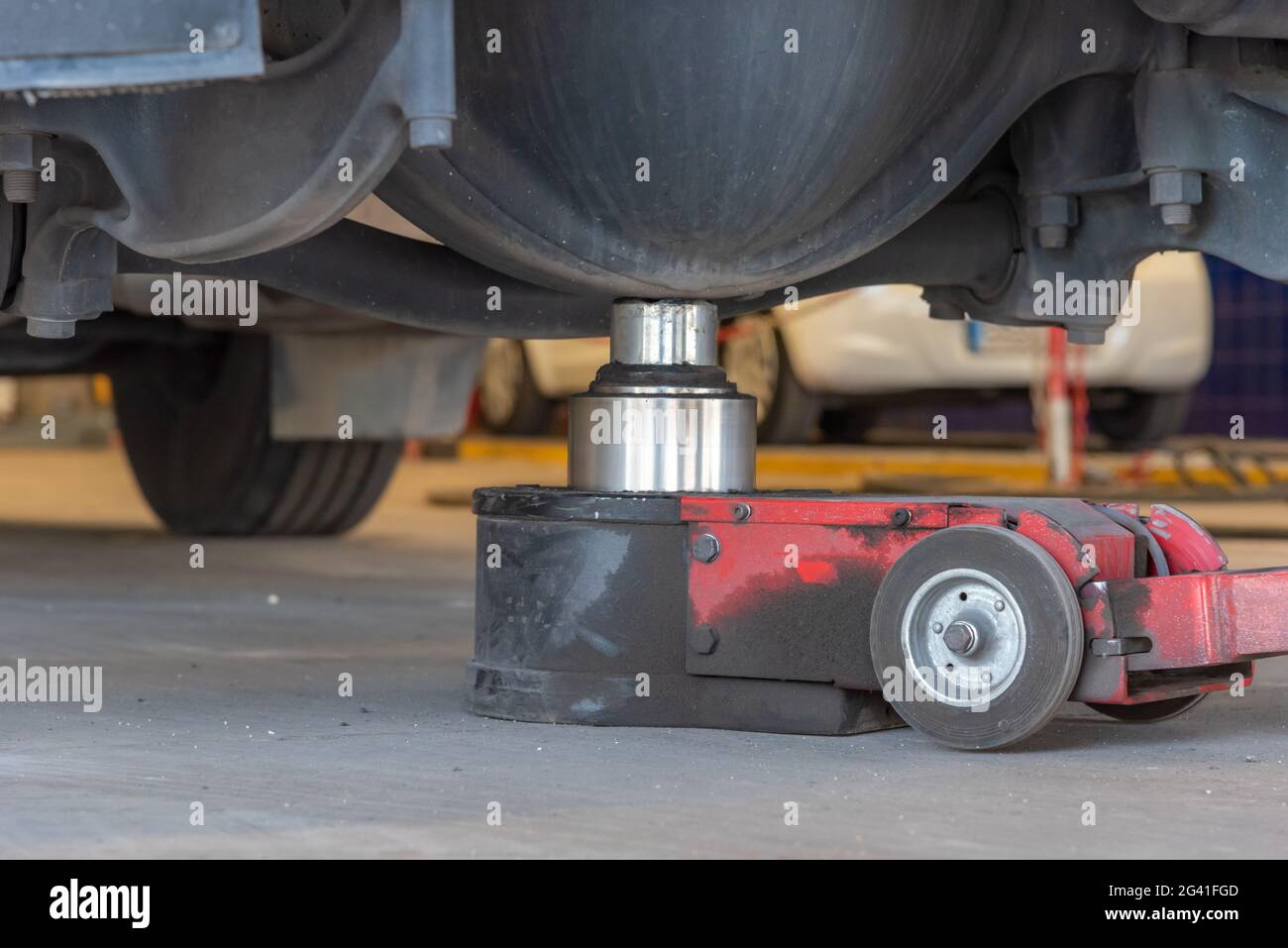 Hydraulic jack lifting a truck from the rear axle. Stock Photo