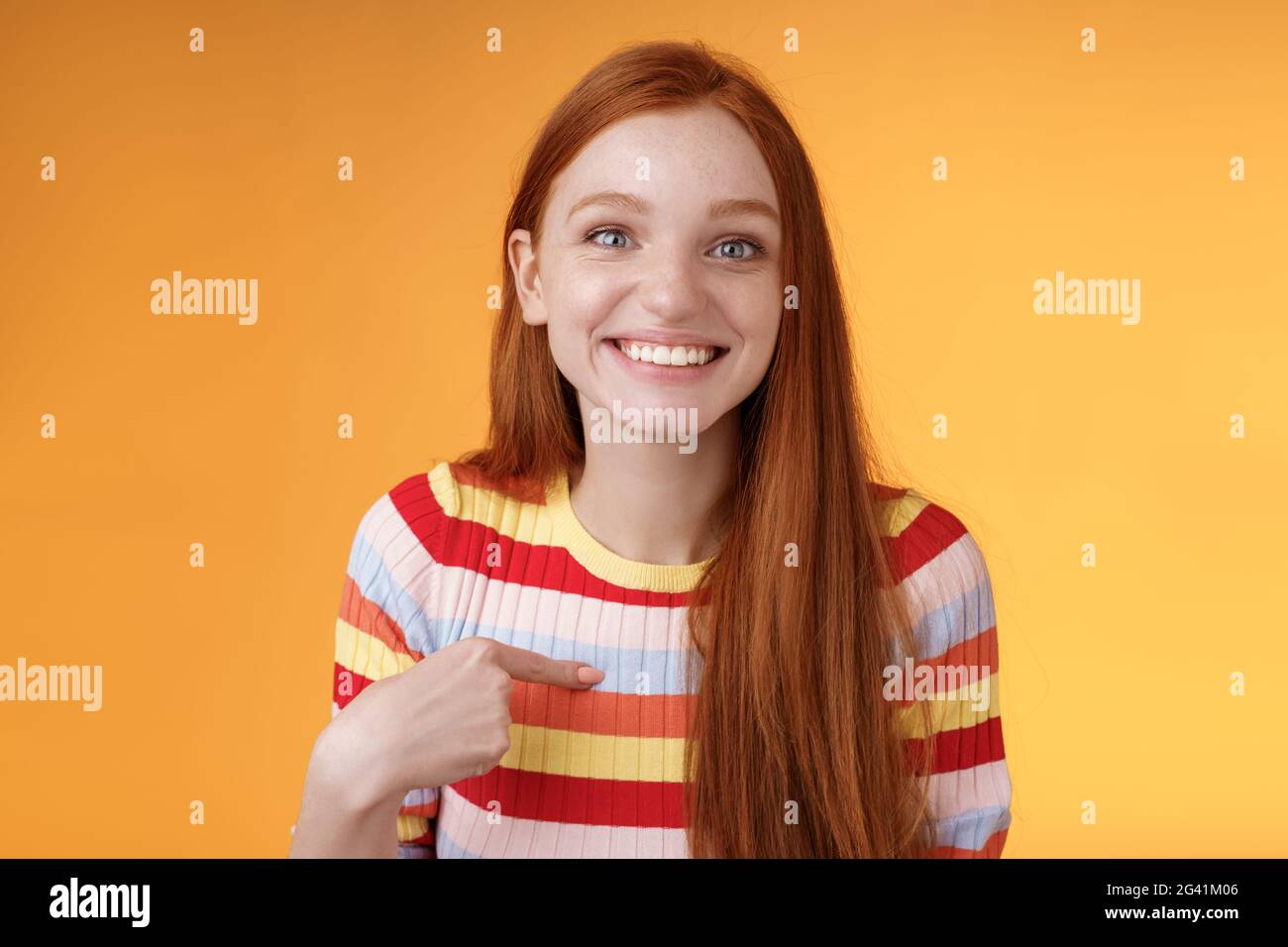 Happy excited grinning redhead girl chosen smiling gratitude delighted gladly pointing herself look surprise thankful camera got Stock Photo
