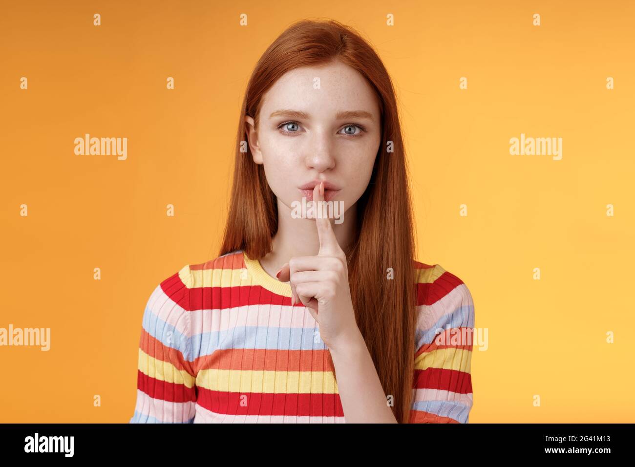 Girl hides lots secrets. Serious-looking redhead girlfriend blue eyes demand keep silent voice down show shhh shush gesture inde Stock Photo