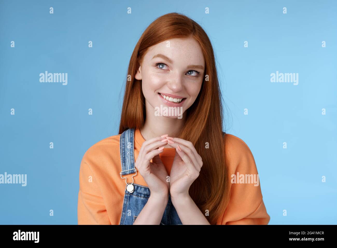 Devious tricky smart pretty redhead girlfriend have evil plan smirking mysteriously look upper left corner twiddles fingers thin Stock Photo