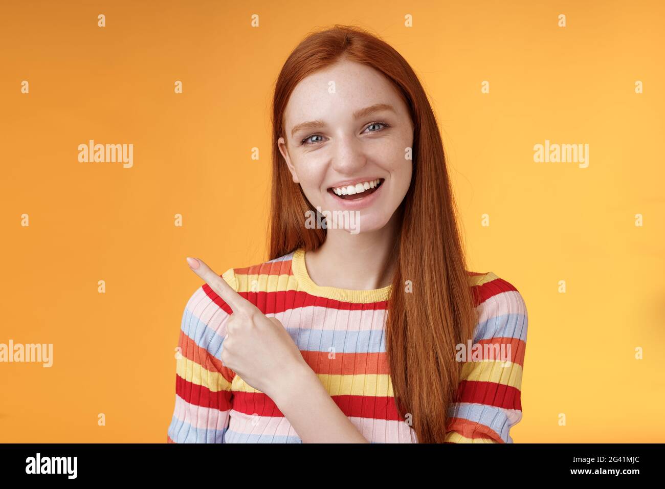 Friendly outgoing good-looking ginger girl university student discussing lecture classmate smiling laughing pointing upper left Stock Photo