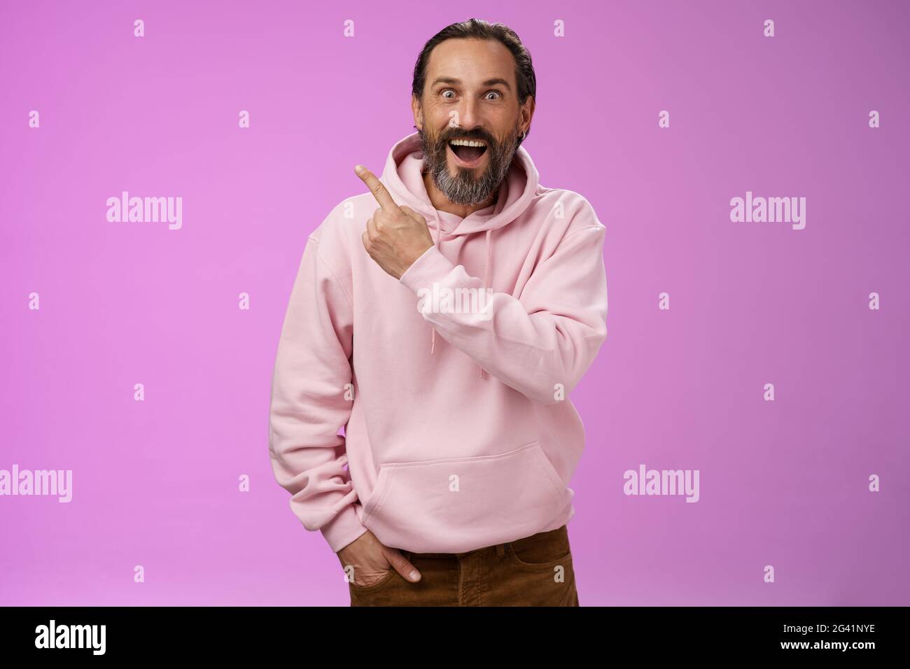 Speechless excited impressed handsome bearded man grey hair widen eyes surprised astonished wow drop jaw gasping thrilled pointi Stock Photo