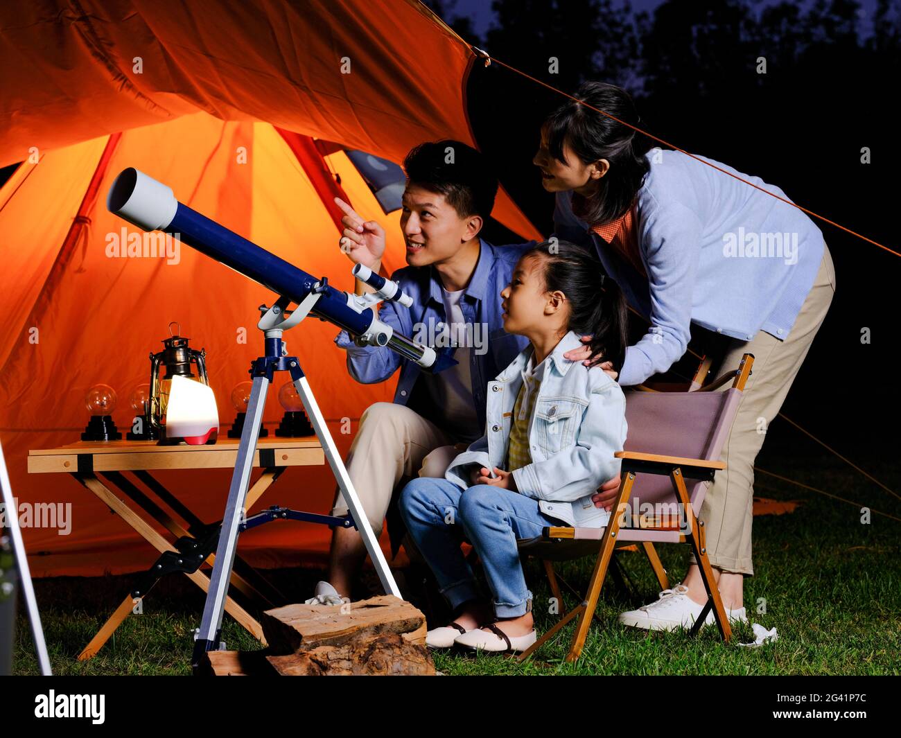 A happy family of three using telescopes outdoors high quality photo