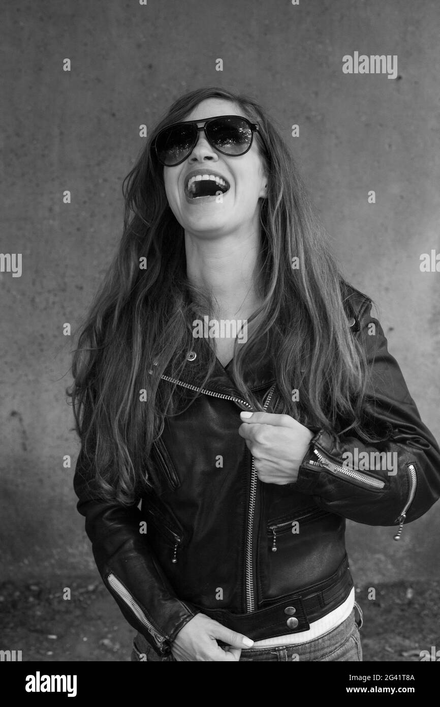 I am ready for rock n roll Inspired young woman in black leather jacket and sunglasses Stock Photo