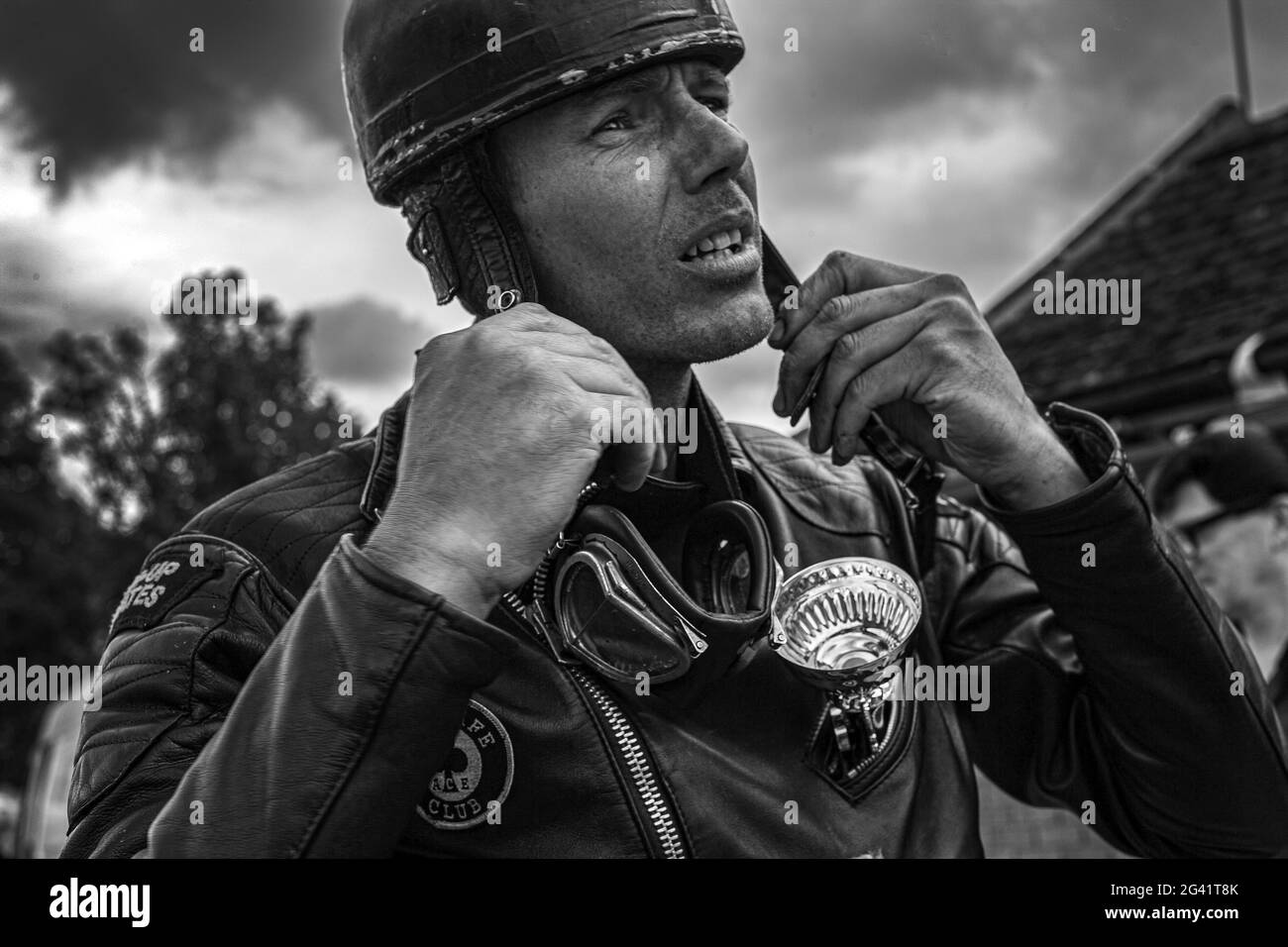 biker ,cafe racer  helmet and goggles getting ready . ton up boy fastening helmet. Stock Photo