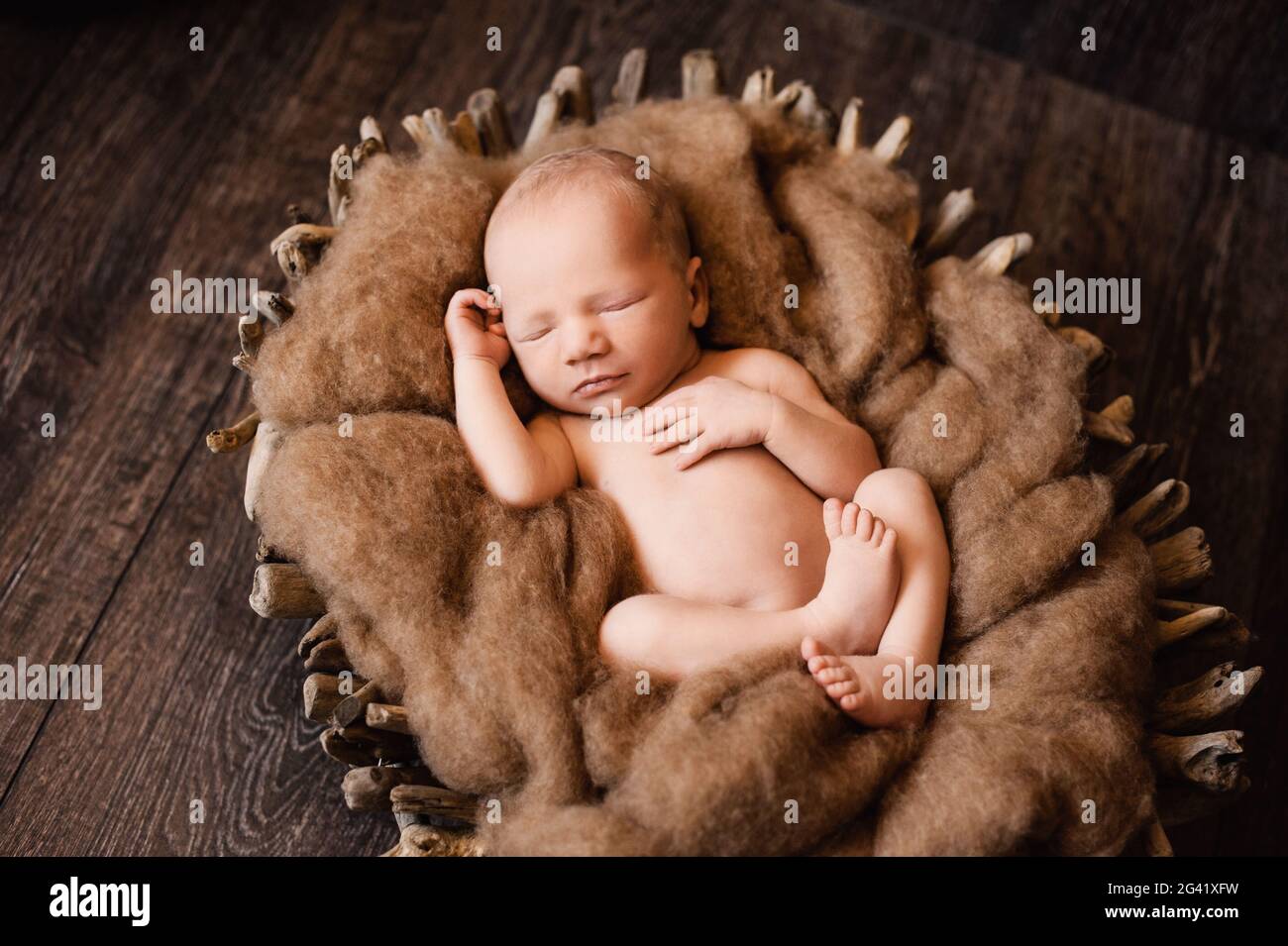 Newborn baby boy is napping in a wooden basket at a newborn photoshoot  Stock Photo - Alamy