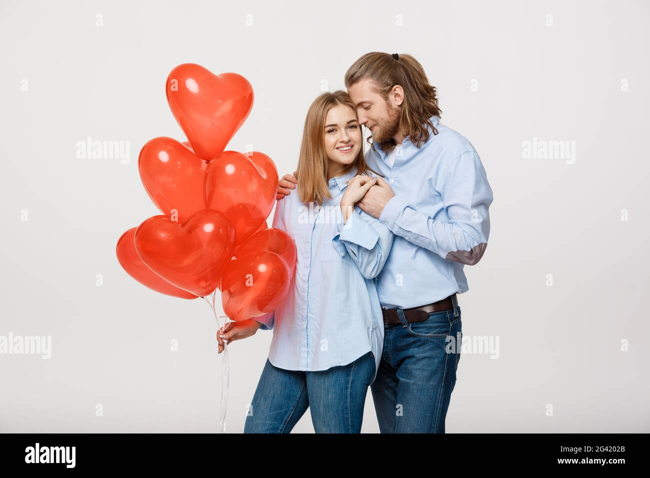 Hugging Balloons Portrait of young fashionable caucasian couple with balloons heart ...